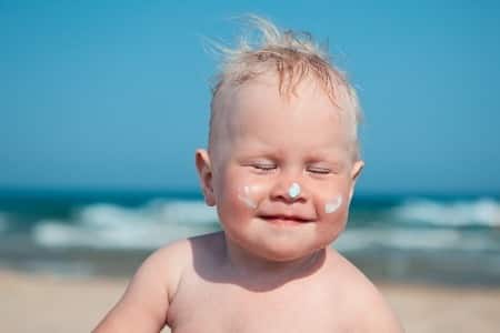 Photo - bébé avec de la crème solaire sur le visage