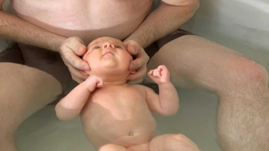 Photo - bébé dans l'eau avec papa pour séance d'ostéopathie