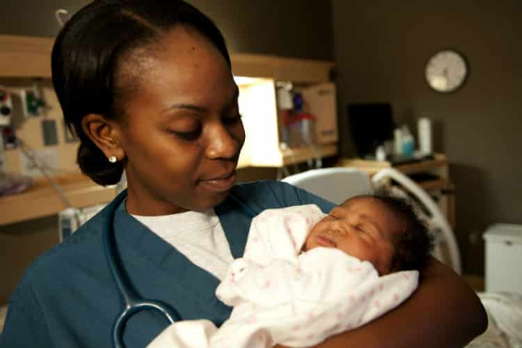 Photo - Infirmière et bébé naissant en salle de travail et d'accouchement