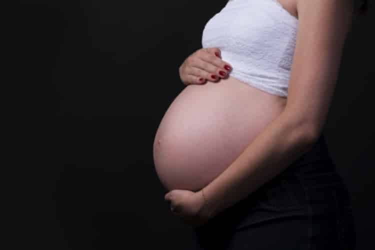 Photo : Femme enceinte avec les mains posées sur son ventre billet la listériose
