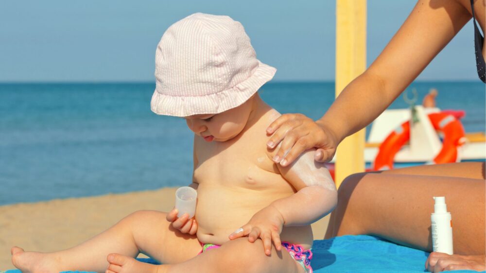 bébé avec de la crème solaire sur le visage